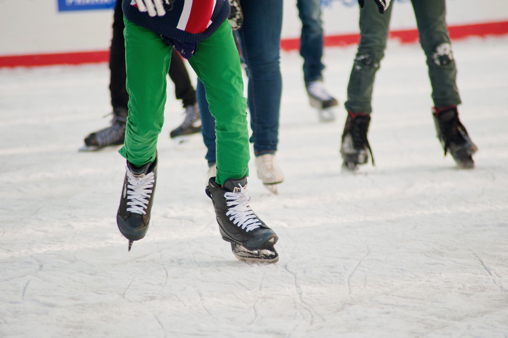 The legs of skaters on an ice rink.