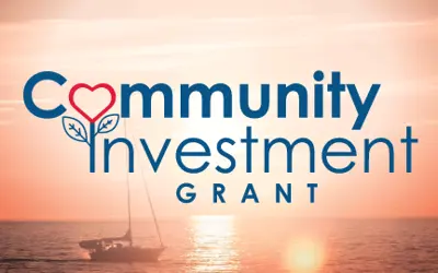 A sailboat on Lake Huron at sunset and logo for Community Investment Grant.