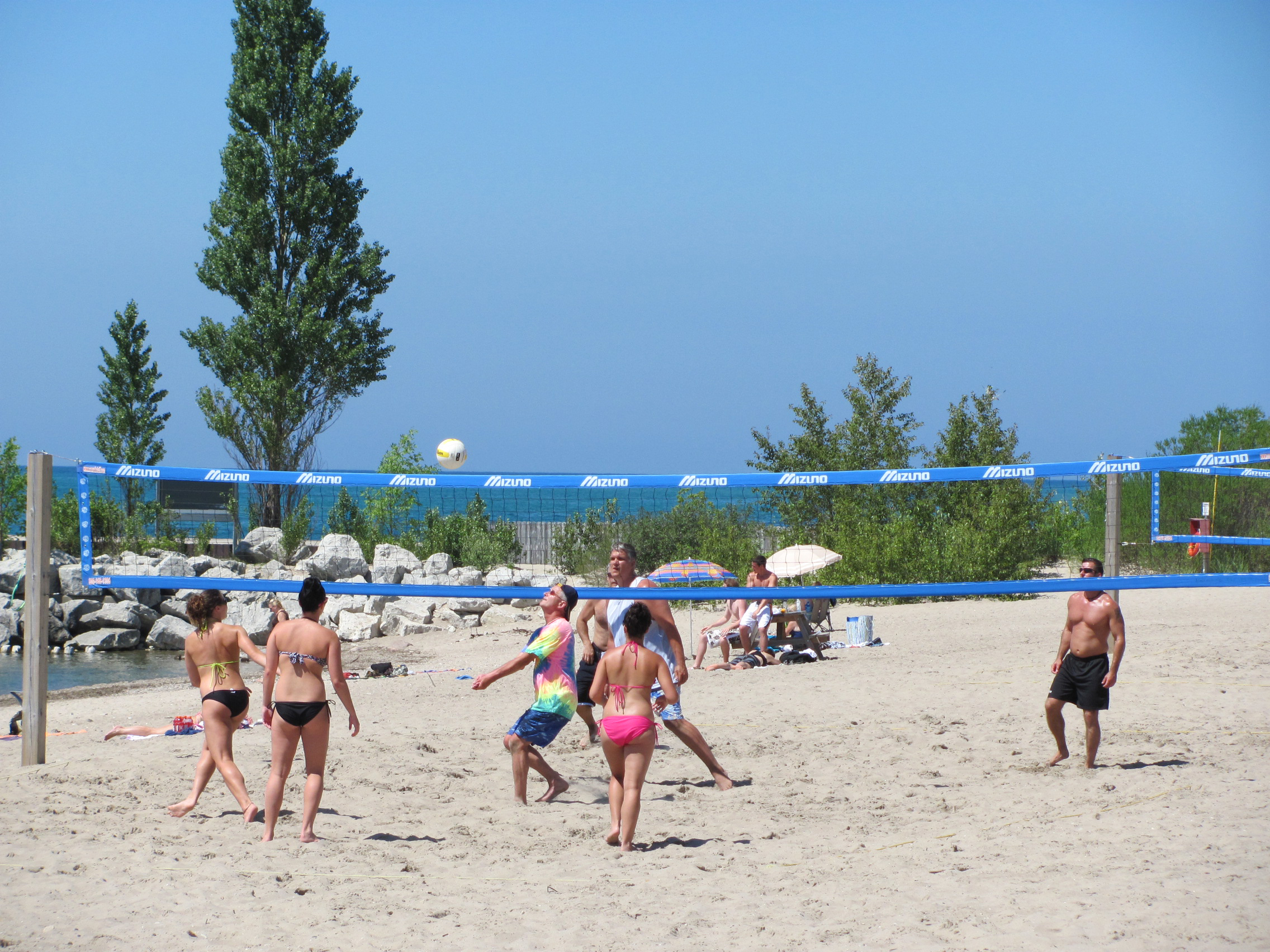 People playing a game of beach volleyball.