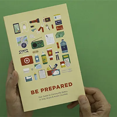A person's hands hold a Be Prepared guide.